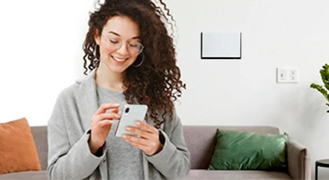Mulher sorrindo usando o celular no sofá da sala com Wi-Fi rápido em casa